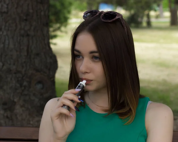 Młoda ładna kobieta pali elektroniczny papieros Zdjęcie Stockowe