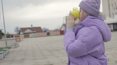 Genç ve güzel kadın içecekler kahve, sokak