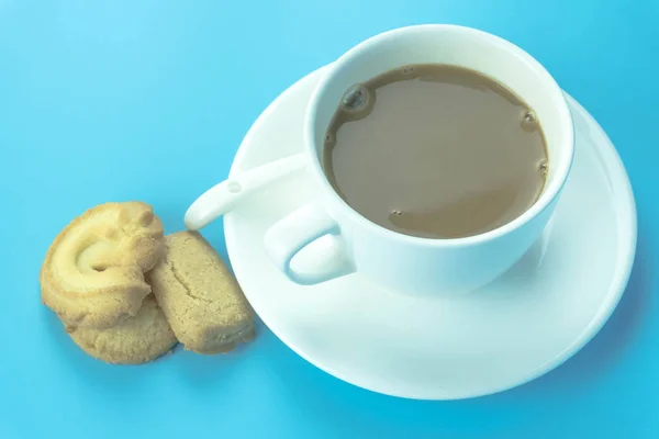 Coffee cup and candy on blue background.