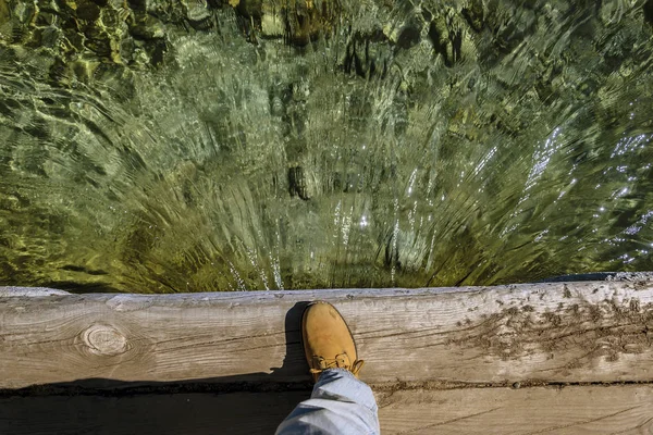 Кто-то наблюдает за прохождением воды под мостом — стоковое фото