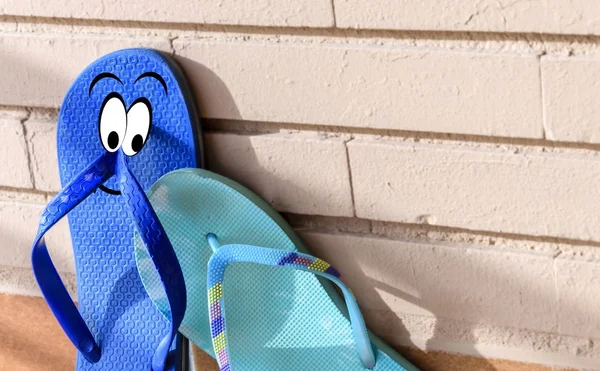 On flip flops a man and a woman show their love on a brick wall