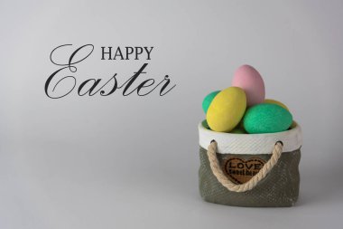 Seramik sepet konseptli renkli paskalya yumurtaları. Beyaz arkaplanda Mutlu Paskalyalar.