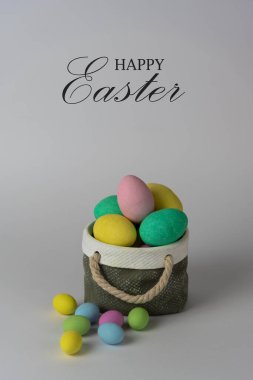 Seramik sepet konseptli renkli paskalya yumurtaları. Beyaz arkaplanda Mutlu Paskalyalar.