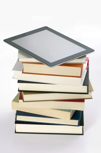 Montagna di libri con tablet