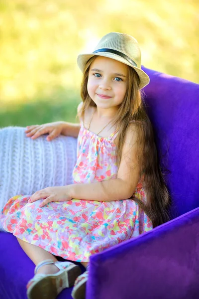Το κορίτσι χαμόγελα και τα θέτει σε μια καρέκλα σε εξωτερικούς χώρους — Φωτογραφία Αρχείου