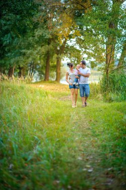 Mutlu aile parkta yürüyor.
