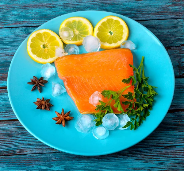 Parte do peixe vermelho está em um prato com um limão — Fotografia de Stock