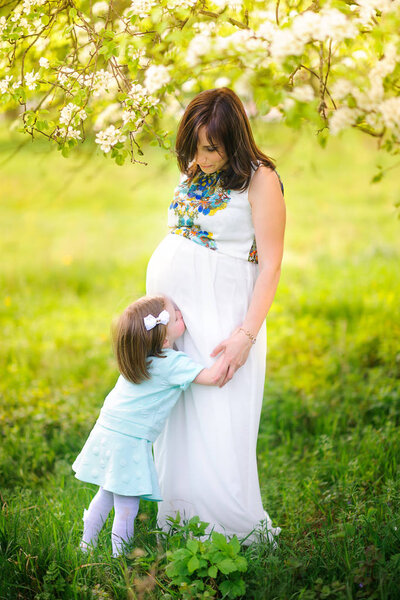 pregnant mother in the park with daughter