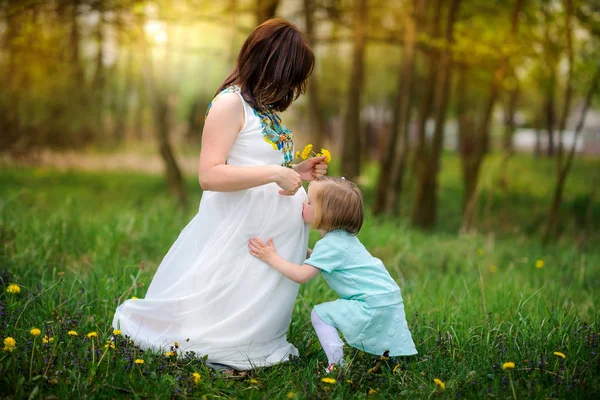 Gravid mamma i parken med dotter — Stockfoto