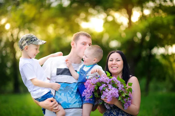 bir gün batımında parkta yürümek mutlu aile, kucaklamak ve öpücük