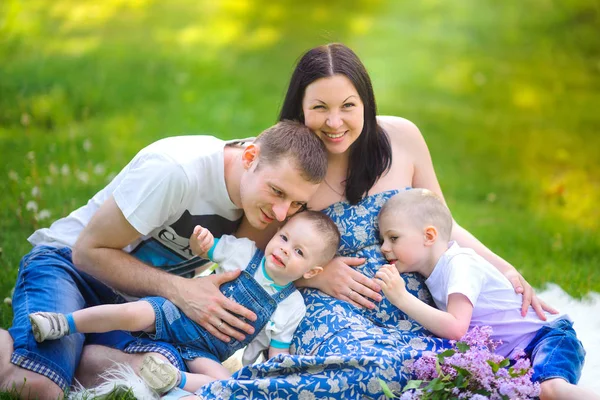 Szczęśliwa Rodzina Spacer Parku Ogarnąć Siedzi Trawie Baw Się — Zdjęcie stockowe