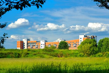 açık güneşli bir günde yeşil bir bölgede inşa edilmiş ev