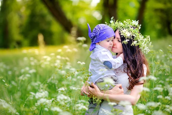 sevgili oğlu ile anne bir gün batımında parkta yürür, güçlü kucaklar ve ellerüzerinde tutar