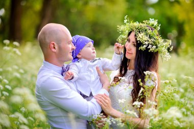 mutlu aile vahşi çiçek çelenk kafasına takmış anne akşam parkta yürüyüş