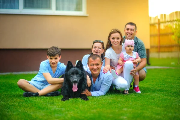 Família Amigável Feliz Juntamente Com Grande Cão Preto Encontra Gramado — Fotografia de Stock