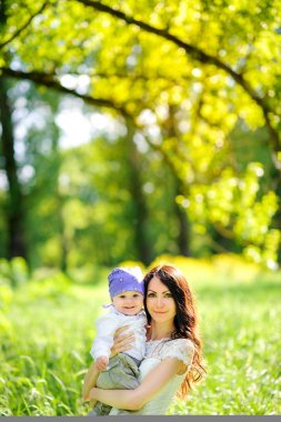 Annesi sevgili bebeği ile akşam parkta yürüyor, onun silah ve hugs sıkıca tutar