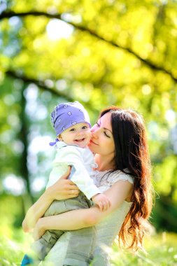 Annesi sevgili bebeği ile akşam parkta yürüyor, onun silah ve hugs sıkıca tutar
