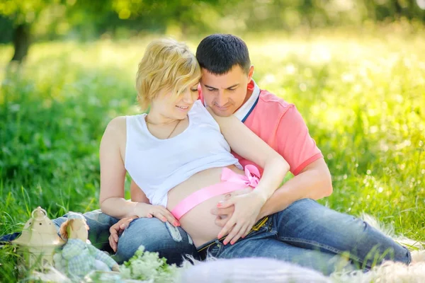 Marido Con Esposa Embarazada Parque Tarde Sentarse Hierba Abrazar Suavemente —  Fotos de Stock