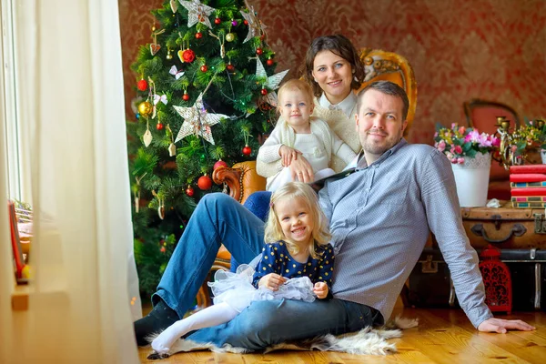 幸せな家族が飾られたお祝い木のそばに座って — ストック写真