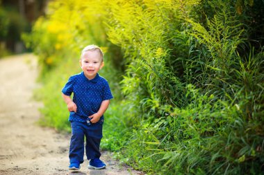 neşeli çocuk güzel bir akşam parkı, gülümseyerek ve playin yürür
