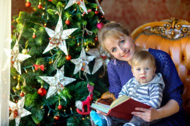 Peri masalları bir Noel ağacı yakınındaki okumak için mutlu anne sevgili ile