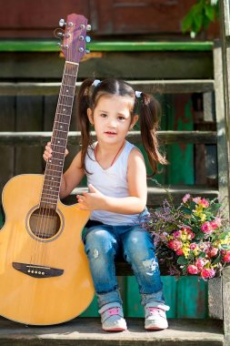 Güzel küçük bir kız ile bir gitar