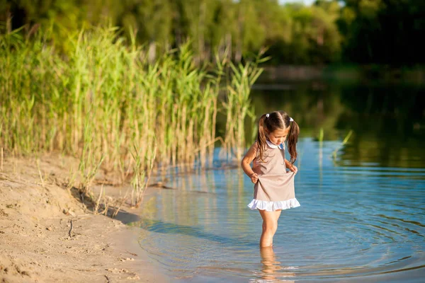 Meisje wandelingen langs de oever van het meer — Stockfoto