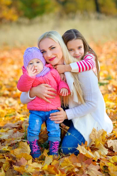 Mother with daughters in autumn park — Stock Photo, Image