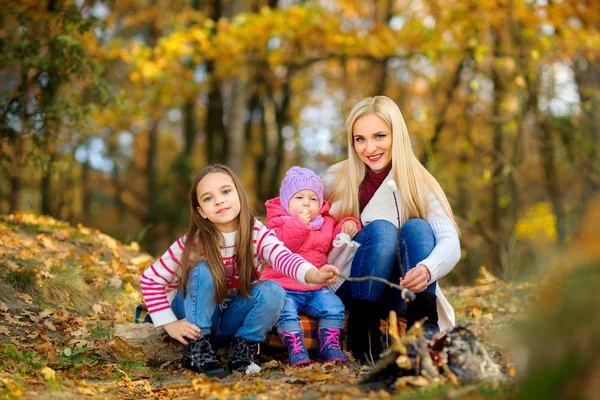 Mother with daughters in autumn park — Stock Photo, Image