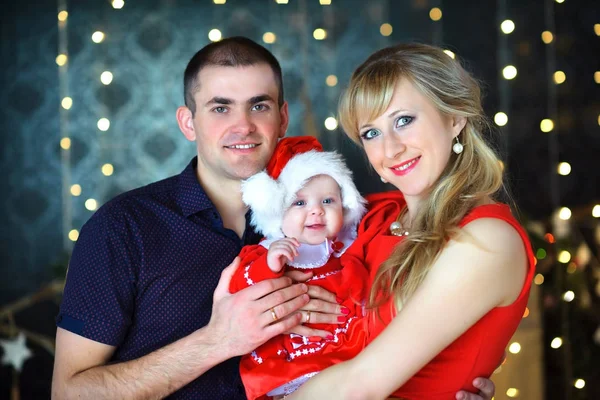 Familia Feliz Con Bebé Traje Santa Claus Abraza Contra Una —  Fotos de Stock