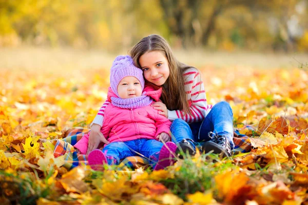 Sisters walking in an autumn park — Stock Photo, Image