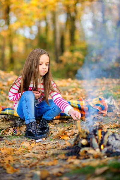 Gelukkig meisje frituren marshmallows in brand — Stockfoto
