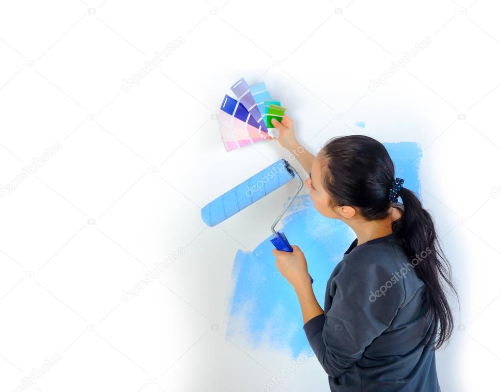 girl picks up the color of paint for painting the walls in her house, the design of the roo