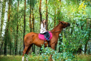 Kız genç güzel bir parkta en sevdiği atının üzerinde en iyi arkadaşı haddeleme
