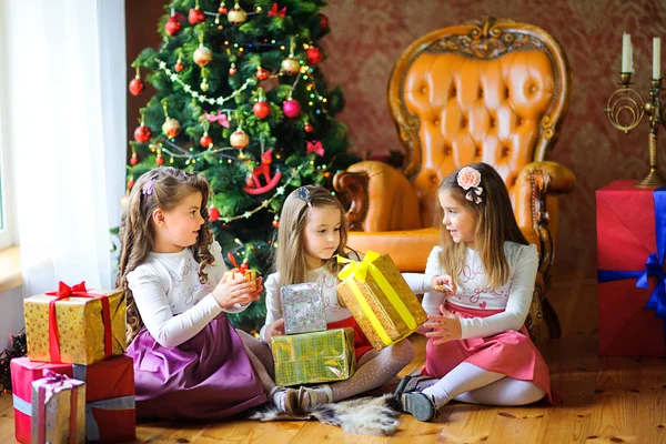 Noel ağacı ve birbirlerine hediye vermek yakın yerdeki kız arkadaşları oturup