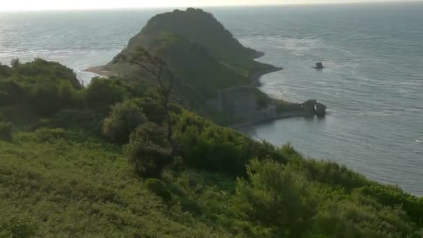 cap sur la côte de l'Albanie sur un coucher de soleil, forteresse à terre détruite 