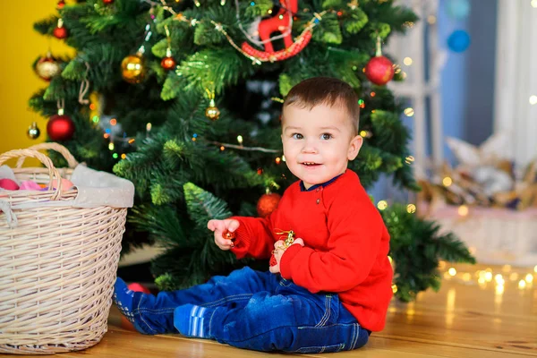 Glückliches Kind Das Auf Dem Festlichen Weihnachtsbaum Sitzt Spielt Und — Stockfoto