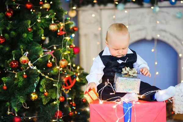 Divertido Niño Sentado Cerca Árbol Navidad Con Regalos Mano —  Fotos de Stock