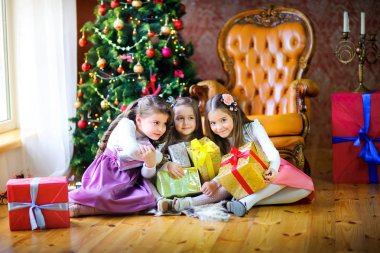 Noel sabahı katta üç kız kardeş hediyeler ile Noel ağacı el yakın: