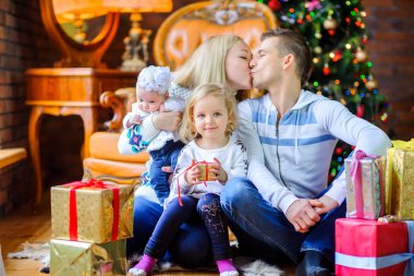 Noel sabahı, birbirimizi sunar, büyük mutlu aile veren bir Noel tre oturan
