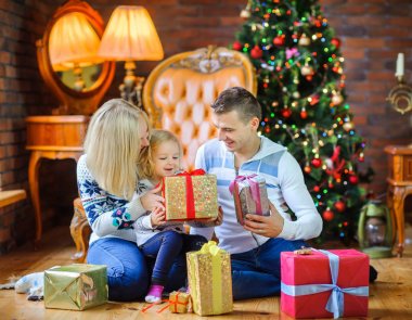Noel sabahı, birbirimizi sunar, büyük mutlu aile veren bir Noel tre oturan