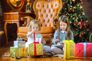 güzel kız yılbaşı ağacı yakınındaki katta oturmak ve hediye açmak