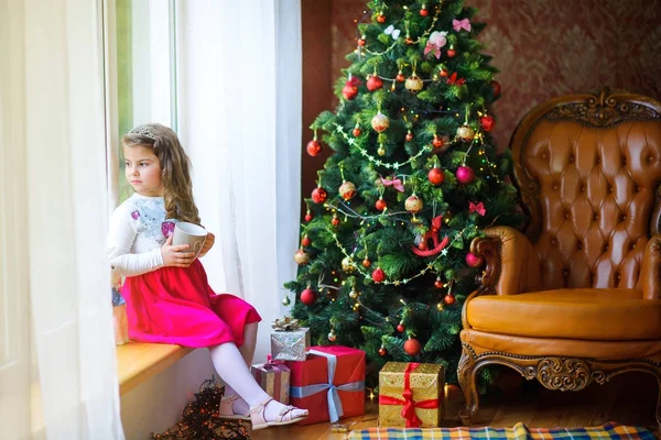küçük kız pencereden dışarı bakarak ve bir şey hakkında hayal pencere üzerinde oturan