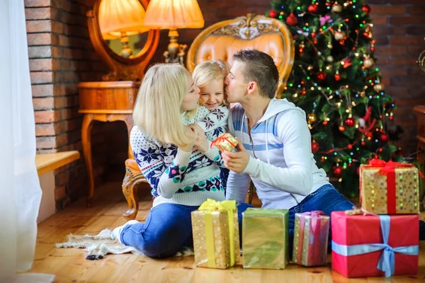 クリスマス ツリー近くの床に坐っている幸せな家族 お互いのプレゼントを渡して — ストック写真