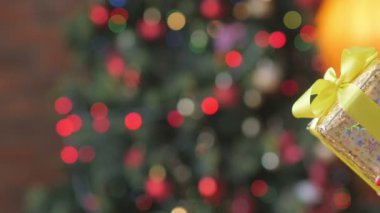 Hediye kutusu. kızına karşı şenlikli bir Noel ağacı parlak ışıkları zemin bir hediye vermek bir kızın yakın çekim