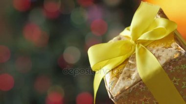 Hediye, bir parlak Festival arka planda sarı kurdele ile altın kağıt sarılı bir büyük hediye kutusu kadar kapatın