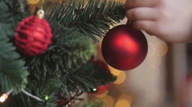 yakın çekim makro atış topu bir Noel ağacı, Noel ağacı süsleme çocuk asılı mutlu bebek el.