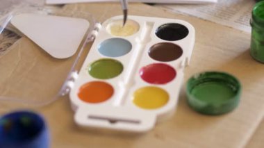 bir sanatçı bir boya fırçası dabs boya içinde bir tablo