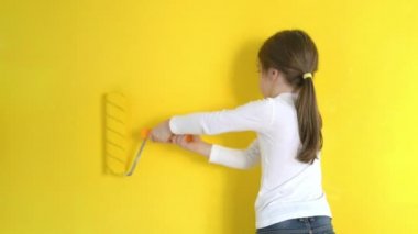 küçük kız, dikkatle duvarları içinde roller ile boyar