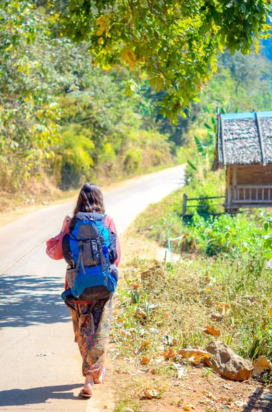 bir sırt çantası ile yol boyunca yürüyüş kız gezgin